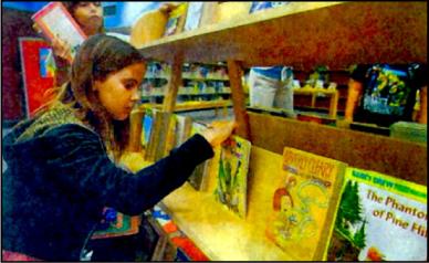 girl browses books at OCHO project book fair
